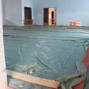 The newly laid screed in the new production hall. The height of the board shows the thickness of the screed, which is necessary to carry the heavy machinery.
