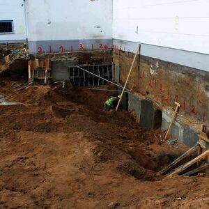 Next to the wall of the bordering building first concrete works for a stable baseplate are made…