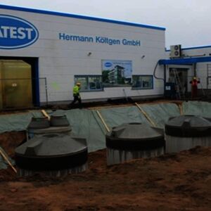 …three huge rain water cisterns and one oil separator including all pipes and wires were put into the 6 m deep construction pit. Afterwards all four cisterns are covered with earth again.