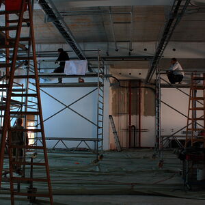 Busy men lay cables and pipes in the new machine hall.